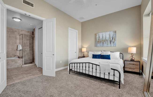 A bedroom with a large bed and a painting on the wall.