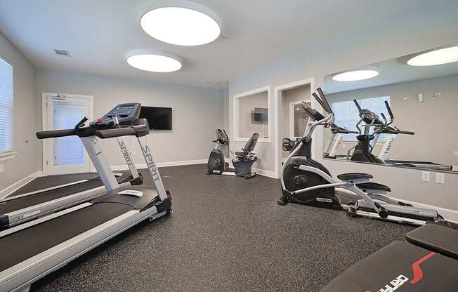 A black kitchen with a refrigerator, sink, and stove.