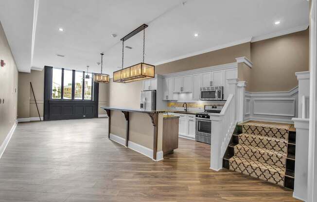 a large kitchen with white cabinets and a large island at The Knights @ 506 Delaware Apartments, New York