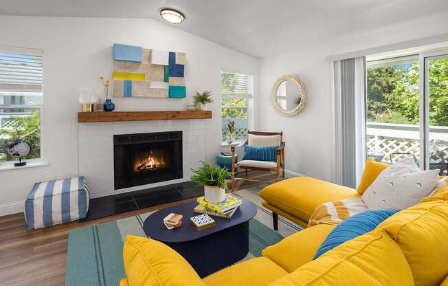 A living room with a fireplace and a yellow couch.