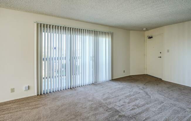 a bedroom with a large window and carpeted flooring at Terrace View Apartments, Daly City California