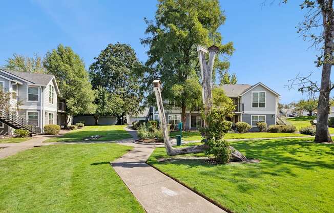 A residential area with houses and a tree in the foreground.
