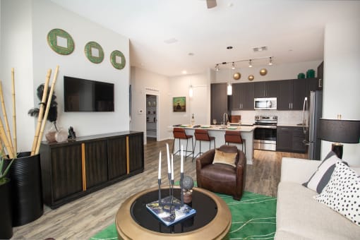 a living room with a couch and a chair and a kitchen