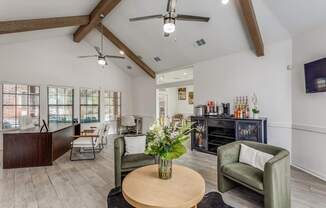 A living room with a wooden table and a green armchair.