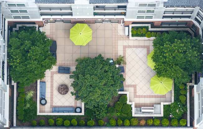 A courtyard with a fountain and umbrella-shaded seating areas.