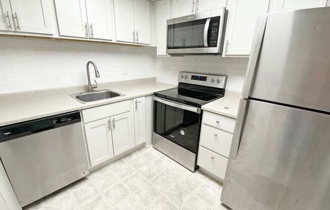 A kitchen with white cabinets and stainless steel appliances.