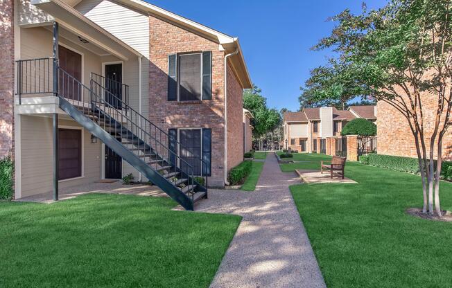 a house with a lawn in front of a brick building