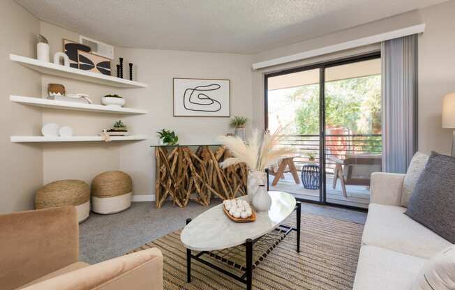 a living room with a sliding glass door that leads to a balcony