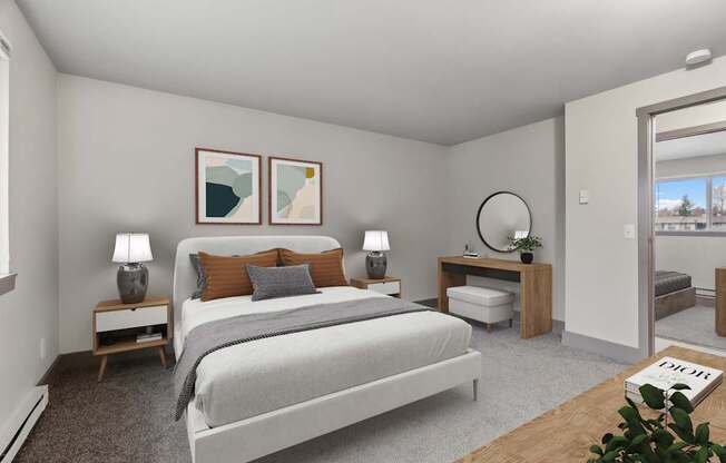 A bedroom with a large bed, two lamps, and a plant.