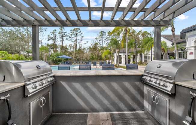 pergola with two grills overlooking pool