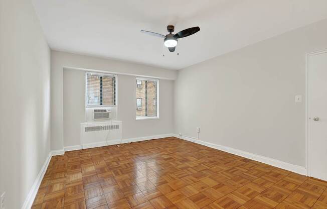 A room with a ceiling fan and a radiator on the wall.