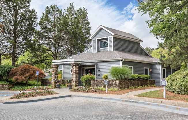 A house with a grey roof and a stone pillar in front.