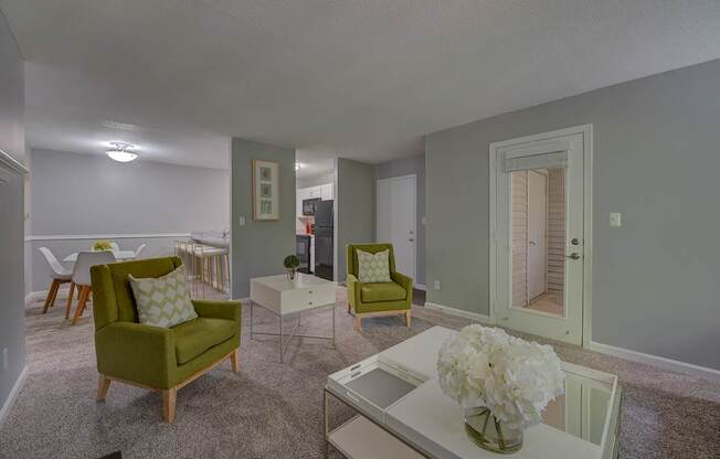 A living room with a green chair and a white coffee table.