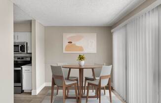 A dining room with a table and chairs.
