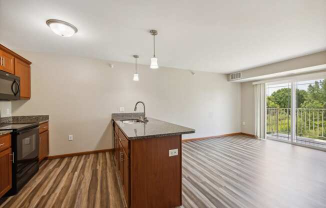 an empty kitchen and living room with a large window