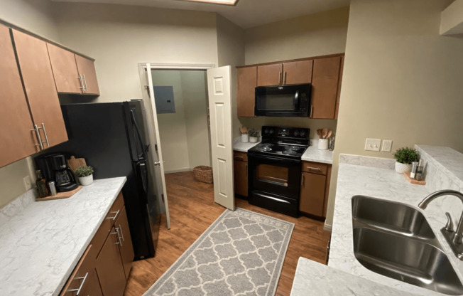 A kitchen with a black refrigerator and stove.