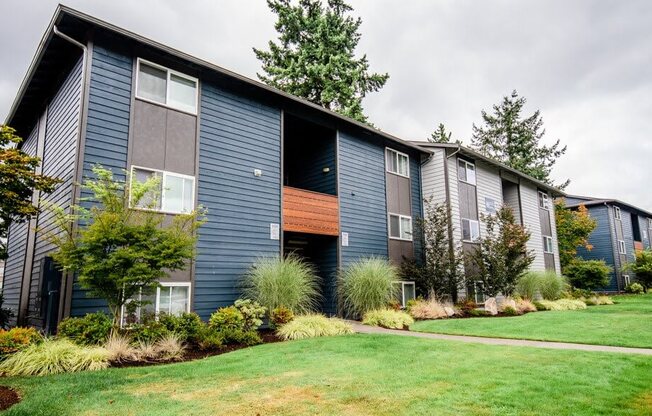 A row of modern townhouses with a green lawn in front. at Vibe, Kent, WA