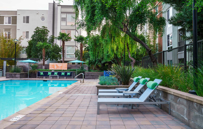 a swimming pool with two chaise lounge chairs     and some buildings