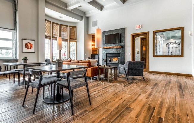 a living room with tables and chairs and a fireplace at The links at Plum Creek Apartments, Castlerock Colorado