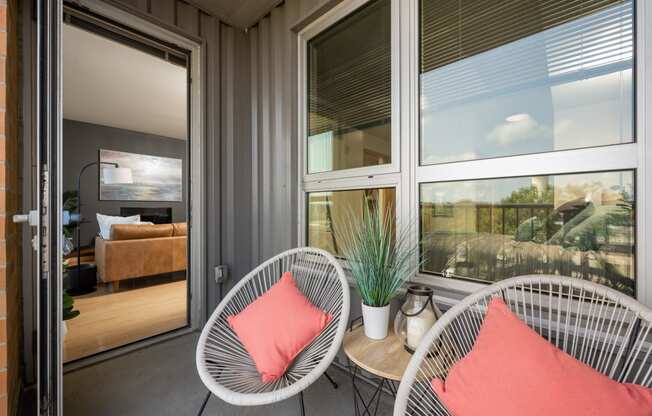 a porch with two chairs and a table and windows