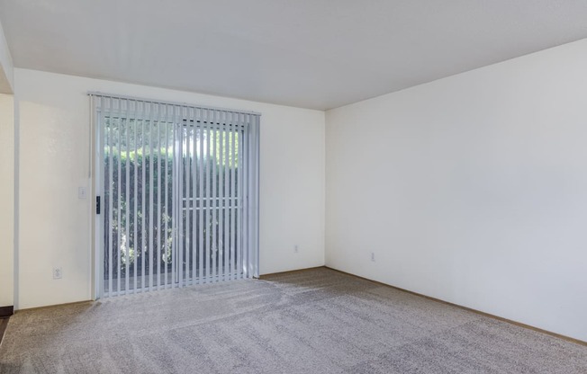 the living room of an apartment with a door to a patio