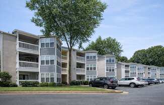 Apartment complex with cars parked in front.