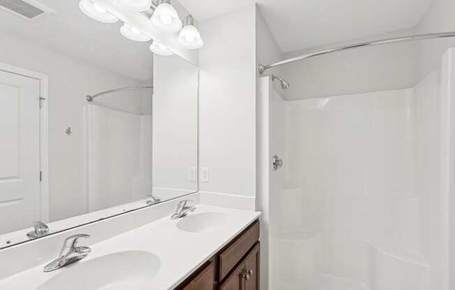 A white bathroom with a sink and mirror.
