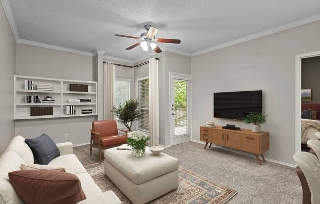 a living room with a ceiling fan and a tv