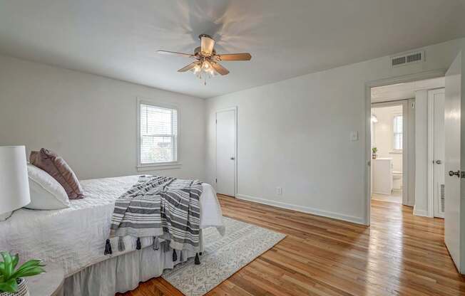 A bedroom with a bed, a ceiling fan, and a rug.