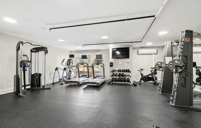 A spacious gym with a variety of equipment including treadmills, weights, and exercise bikes.
