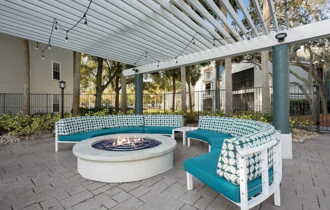 Covered Outdoor Fire Pit Area with Cushioned Patio Furniture at Caribbean Breeze Apartments in Tampa, FL.