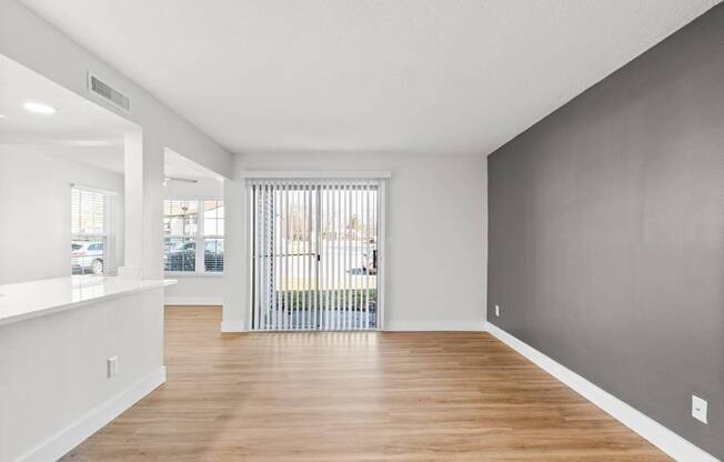 A spacious room with wooden floors and white walls.
