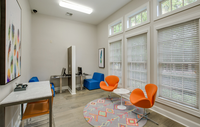 View of Business Center with Seating Areas, Wood Flooring, and Computer Areas at Raveneaux Apartments