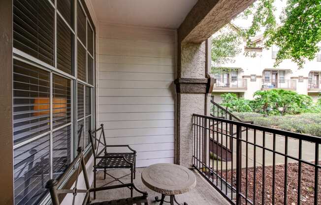 a balcony with a table and two chairs on it