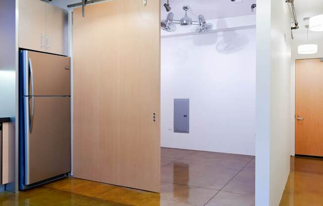A kitchen with a refrigerator and a wooden door.at Arc Light, San Francisco