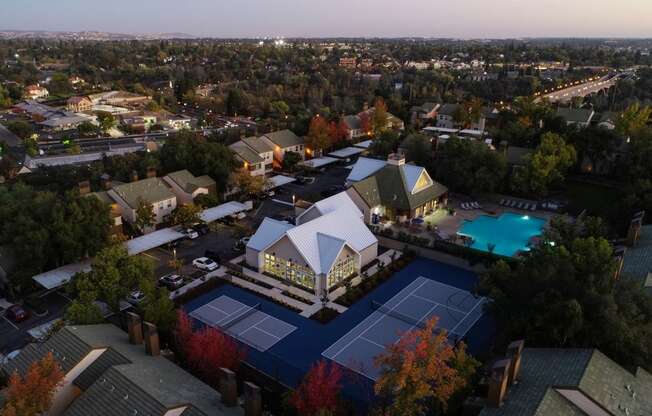 Drone Shot at Dusk with Apartment Roofs, Trees, Pool and Tennis Courtand Roads