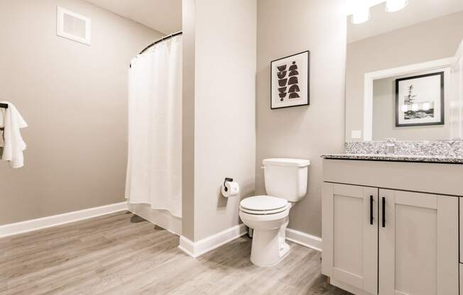 a bathroom with a toilet and a shower and a sink