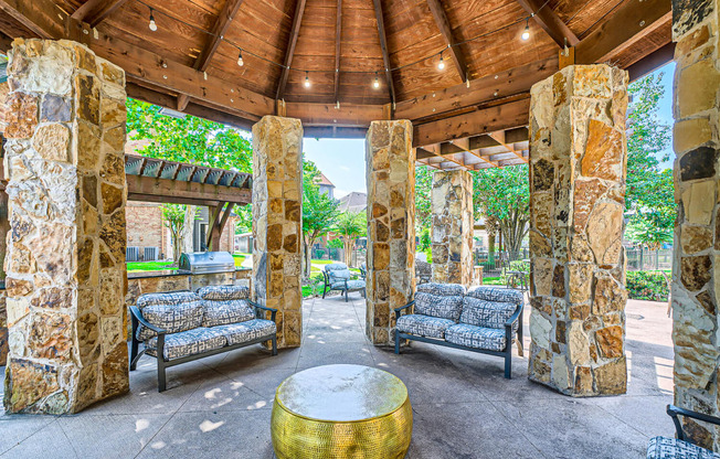 a covered patio with couches and a table at River Pointe, Texas