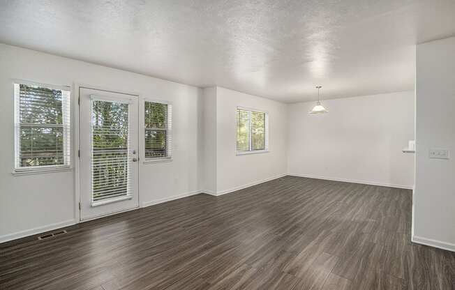 A living room with vinyl plank flooring and white walls at Foxwood and The Hermitage, Portage, MI, 49024