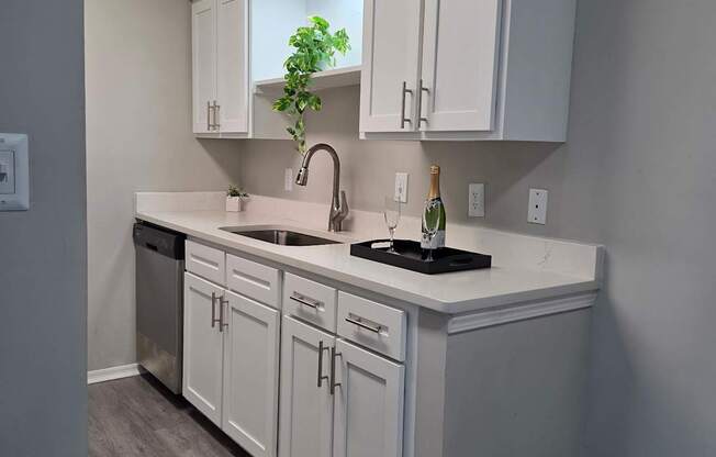 A kitchen with white cabinets and a black countertop.