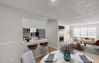 a kitchen and living room with a table and chairs at Highland Park Apartment Homes, Overland Park