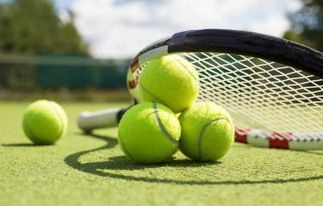 a group of tennis balls and a racket on a court