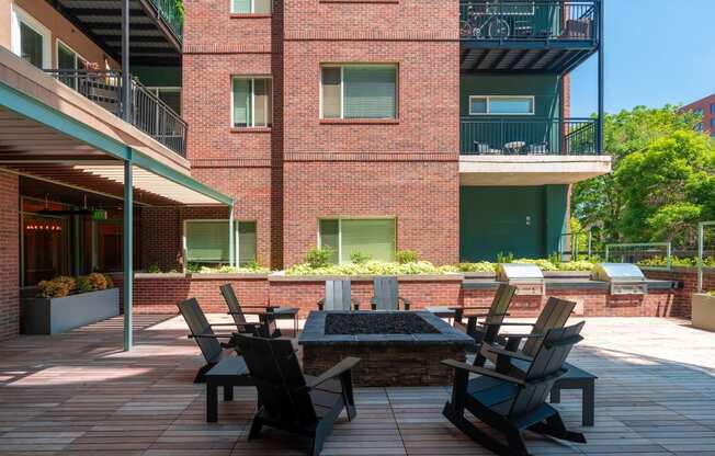 Red brick outdoor patio with chairs surrounding a fire pit at Sylvan Uptown, Colorado, 80203