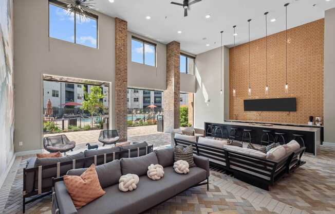 a large lobby with couches and chairs and a bar and windows