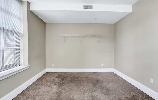 an empty room with carpet and a large window