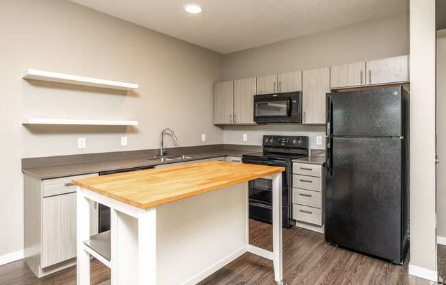 a kitchen with black appliances and a wooden counter top