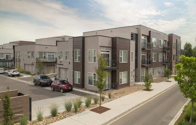 a rendering of an apartment building with cars parked in a parking lot