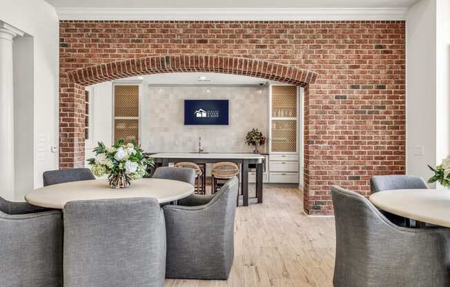 a dining room with a brick wall and a table with chairs