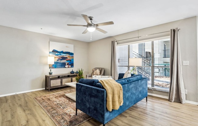 a living room with a blue couch and a ceiling fan at Reserve at Temple Terrace, Temple Terrace