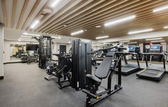 a gym with cardio equipment and weights in a large room